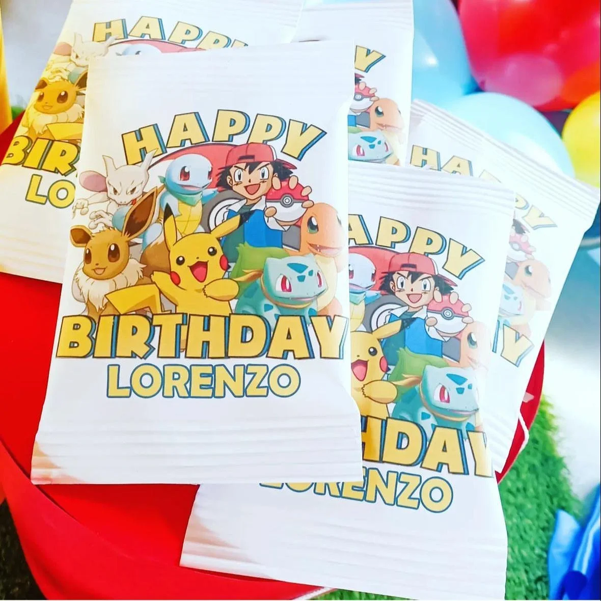 Sacchetti di carta con disegni di Pokémon e personaggi di Pokémon, con la scritta 'Happy Birthday Lorenzo'.