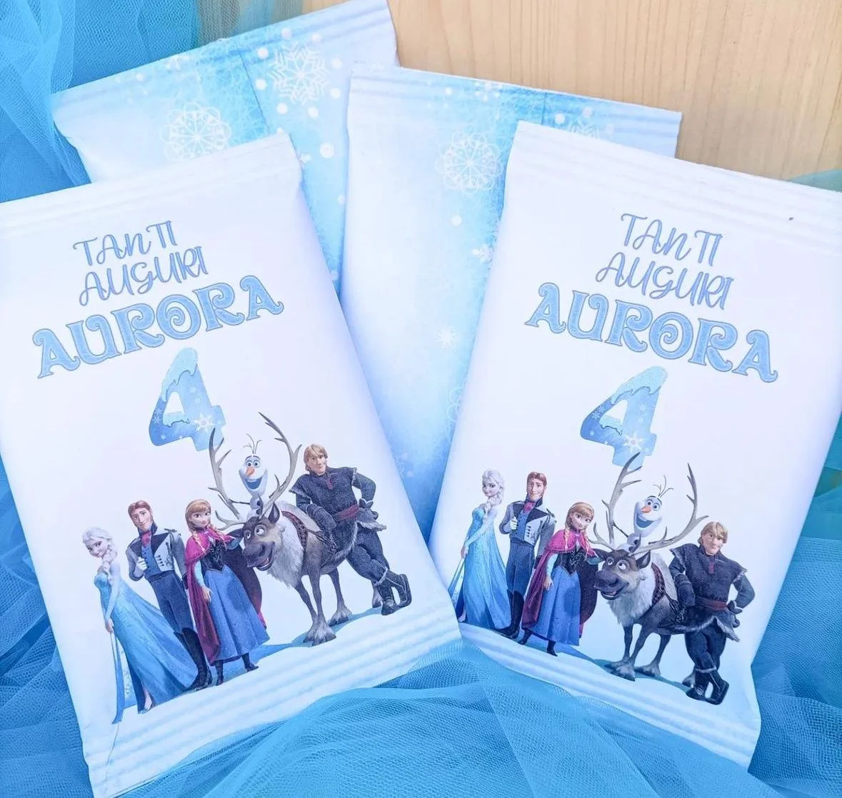 Libri o quaderni con copertina dedicata a Elsa, Anna, Olaf e Sven da Frozen, con decorazioni in stile invernale e testi in italiano per un compleanno di 4 anni.