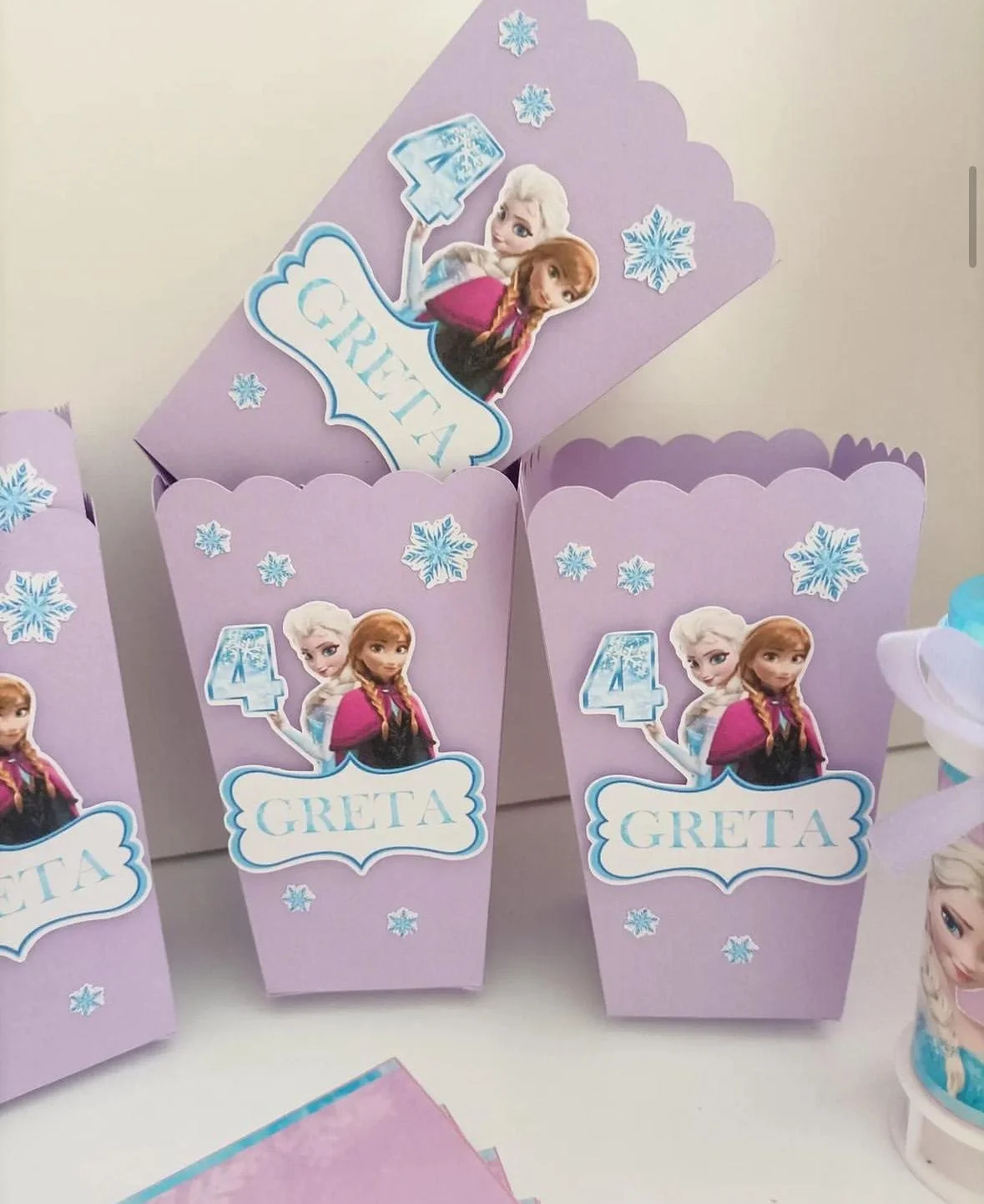 Cono porta dolci viola decorato con immagini di Elsa e Anna dal film Frozen, con fiocchi di neve e il nome Gretà.