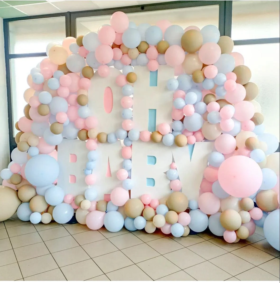 Decorazione di palloncini color pastello con le parole 'Oh Baby' in grandi lettere bianche.