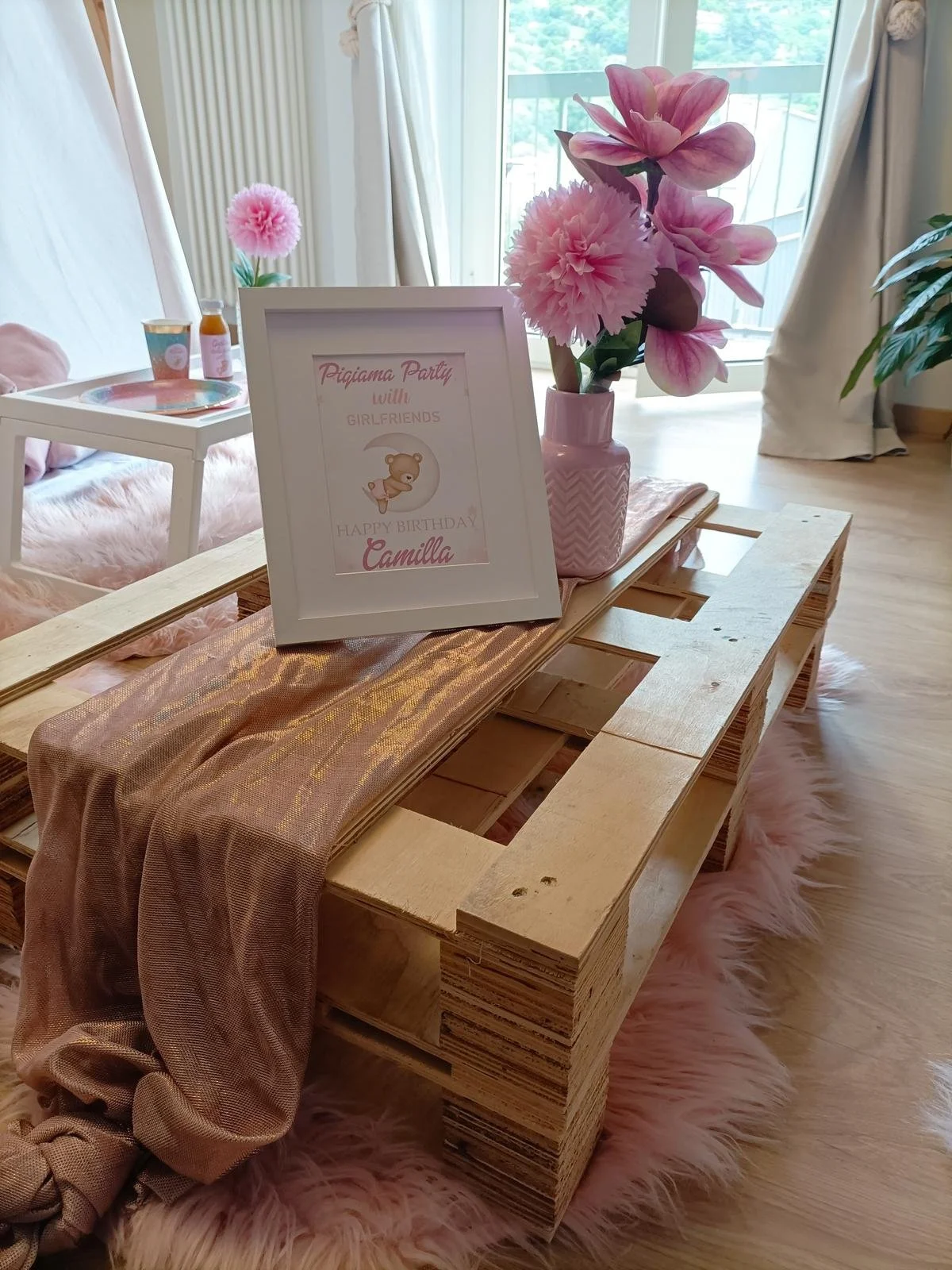Decorazioni rosa, una pianta in vaso rosa, una cornice con scritto 