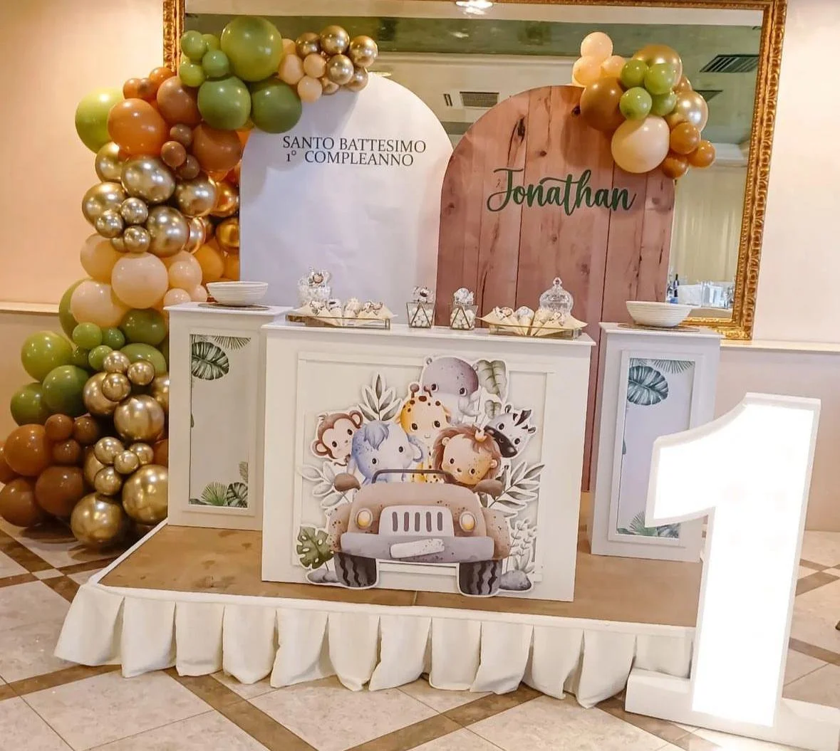 Decorazione per festa di battesimo e primo compleanno di bambino con ballon colorati, cartellone con il nome Jonathan e decorazioni su tavolo